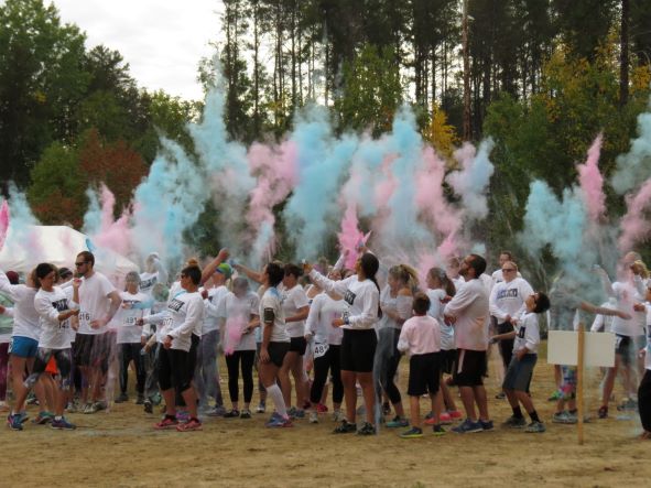 start line of runners throwing colour in air